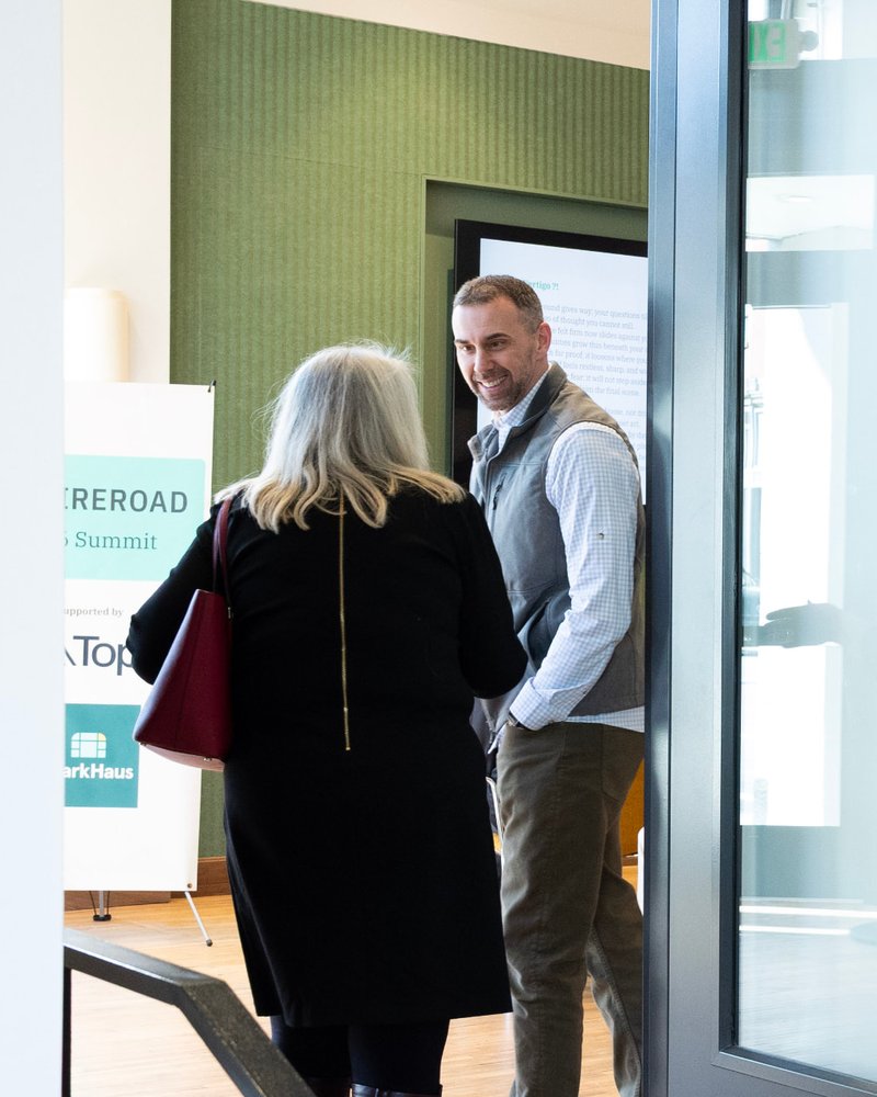 Two attendees talking by the entrance at the Fireroad Summit