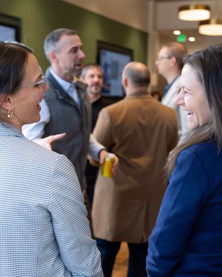 Two attendees laughing together at the annual meeting